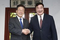 Chinese Ambassador to South Korea Xing Haiming, right, shakes hands with South Korea's main opposition Democratic Party leader Lee Jae-myung