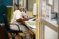 Army 1st Lt. Courtney Arthur, a registered nurse, checks patient records in the intensive care unit of Guam Memorial Hospital (GMH).