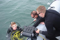 Sailors attending Navy Explosive Ordnance Disposal School assist a seaman after an underwater search mission in the Gulf of Mexico.