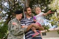 Military family with their daughter outside.