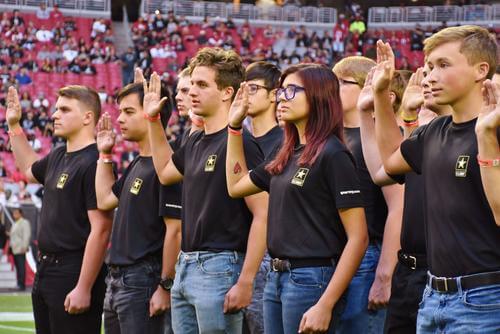 Future soldiers recite the oath of enlistment before an NFL game in Phoenix.