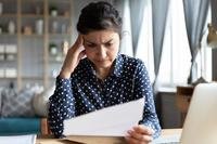 A woman examines a piece of paper.