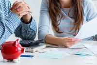 A man, left, and woman appear to look over financial papers.