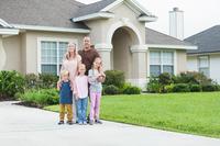 Family outside suburban house.