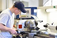 student running a lathe in technical school